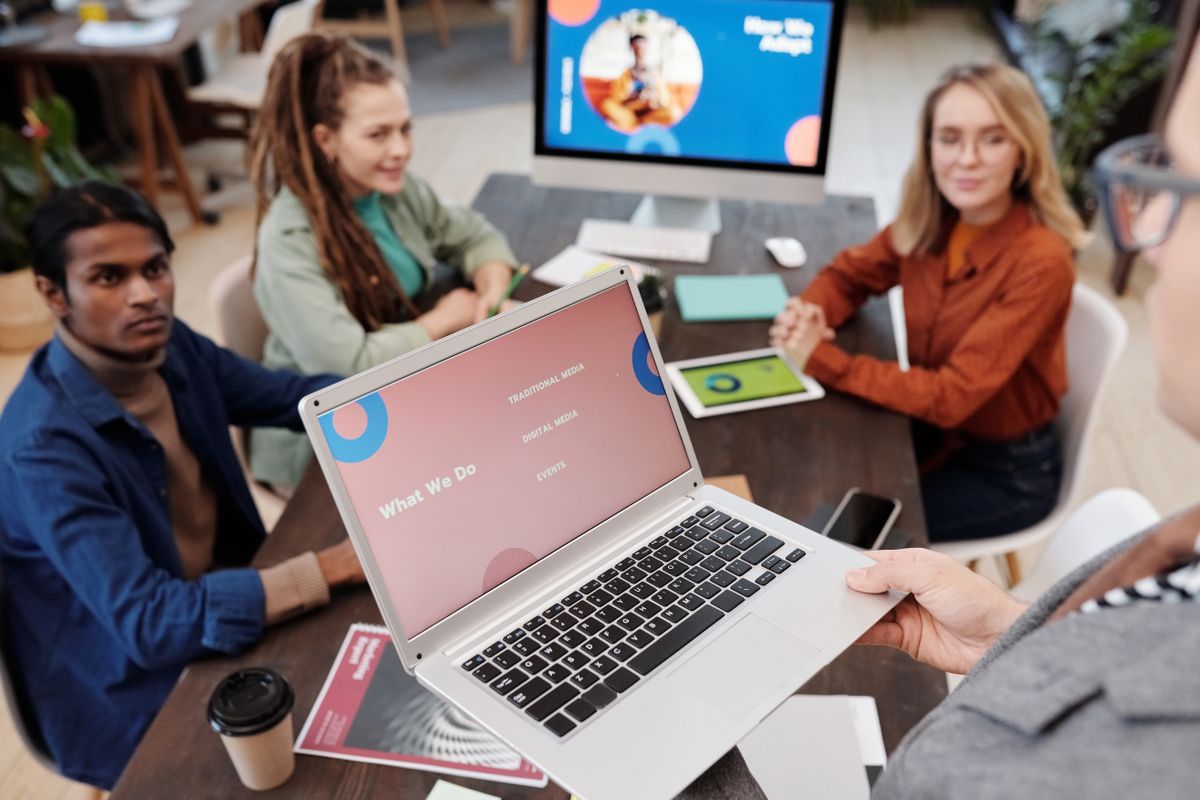 Marketing team collaborating around a laptop